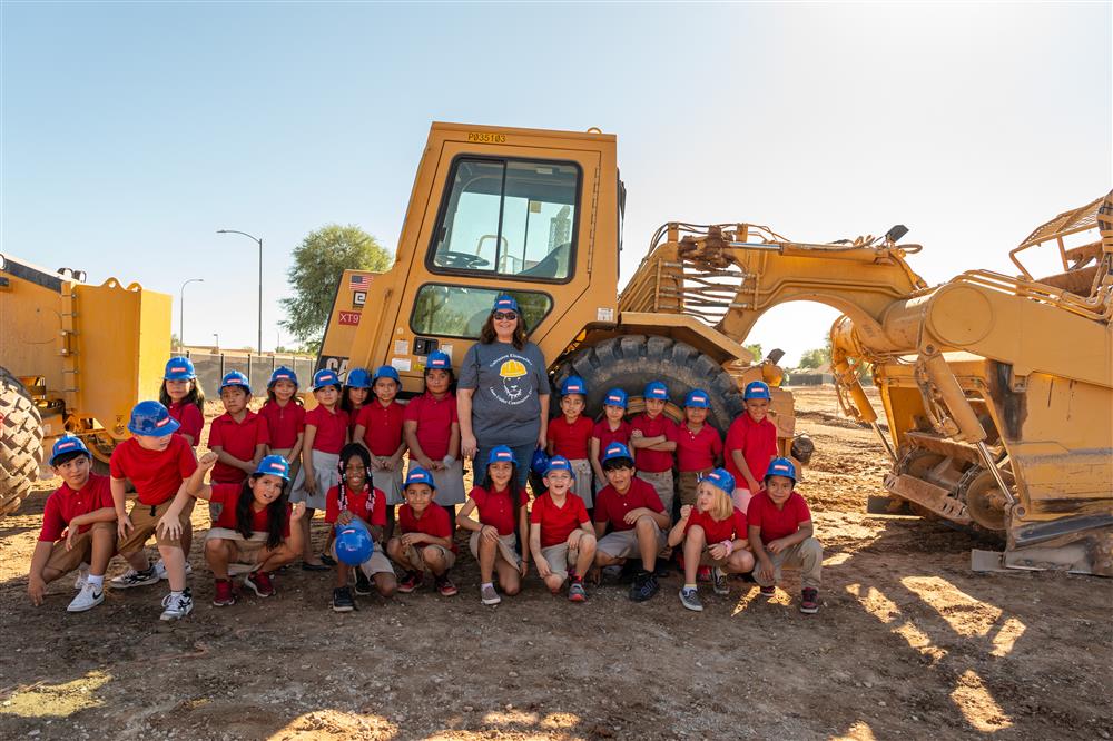 Students pose for the photo by a bulldozer